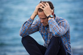 man-in-blue-and-brown-plaid-dress-shirt-touching-his-hair-897817