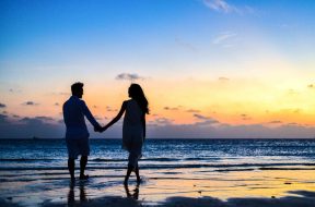 man-and-woman-holding-hands-walking-on-seashore-during-1024960