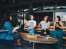 four-women-chatting-while-sitting-on-bench-1267697