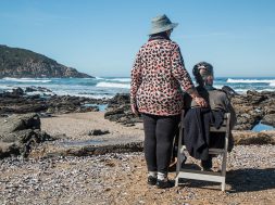 woman-standing-beside-woman-on-white-wooden-chair-facing-160767