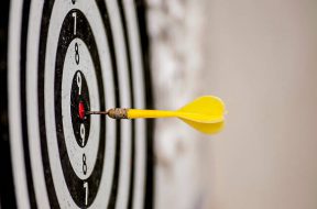 shallow depth of field shot of darts in bullseye on dartboard