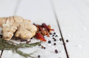 collection of spicy kitchen ingredients. rosemary, ginger, red chili, cloves, salt and pepper.