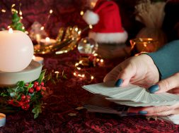 Blurred Tarot cards on table near burning candles. Tarot reader or Fortune teller reading on Christmas decoration