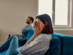 Unhappy Couple After an Argument in the Living Room at Home. Sad Pensive Young Girl Thinking of Relationships Problems Sitting on Sofa With Offended Boyfriend, Conflicts in Marriage, Upset Couple After Fight Dispute, Making Decision of Breaking Up Get Divorced