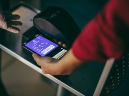 Unrecognizable woman scans smart phone at airport check in. Digital scanning on boarding pass at airport check in counter.