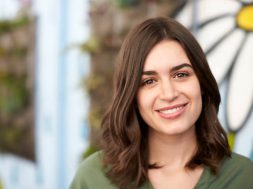 Outdoor Head And Shoulders Portrait Of Smiling Young Woman