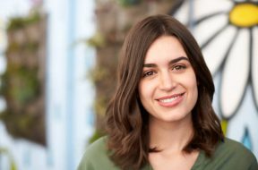 Outdoor Head And Shoulders Portrait Of Smiling Young Woman