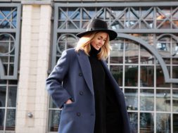 Lifestyle portrait of fashionable woman wearing winter or spring outfit, felt hat, gray wool coat, turtleneck. Outdoors. Female stylish Model smiling, walking city Street. Street fashion trend